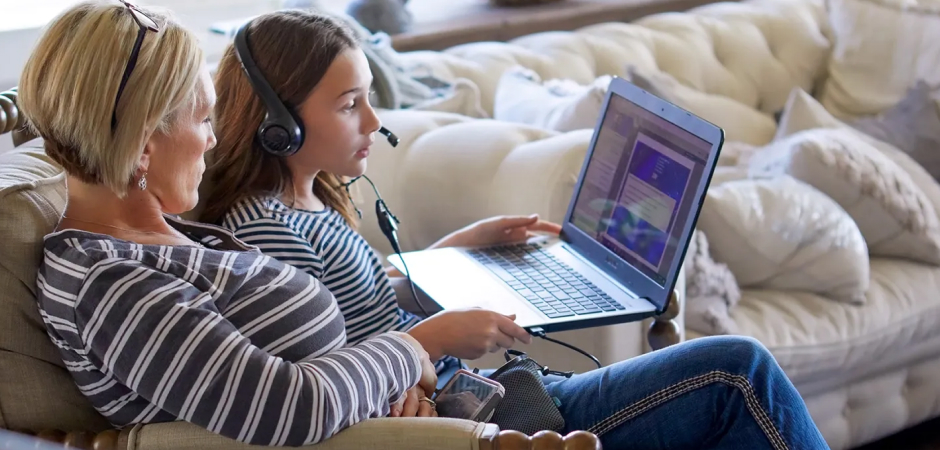 Mother and daughter working on their laptop at home