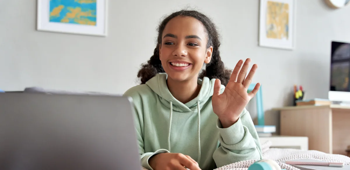girl saying hi to the computer camera